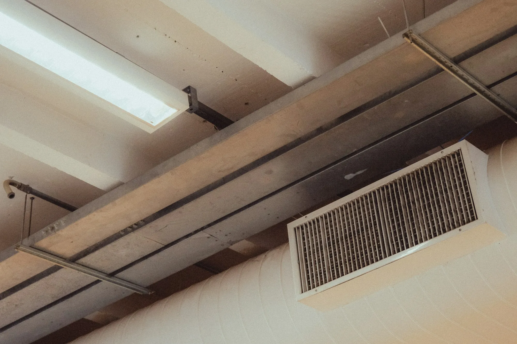 Return air grille on a wall under ceiling beams
